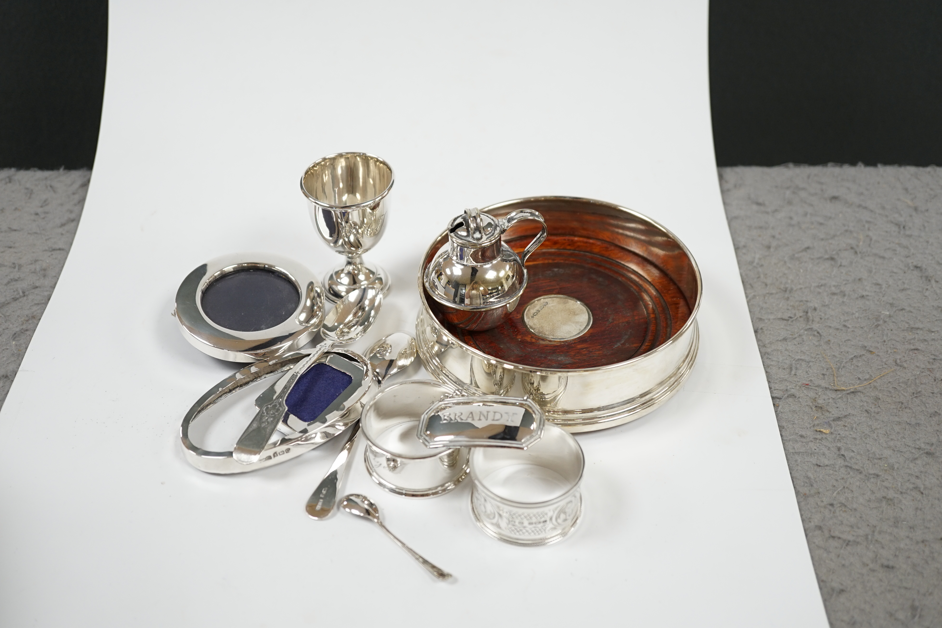 A modern silver mounted wine label and a quantity of sundry small silver including wine labels, small photograph frames, napkin rings, flatware etc. and a plated Guernsey milk can condiment. Condition - fair to good